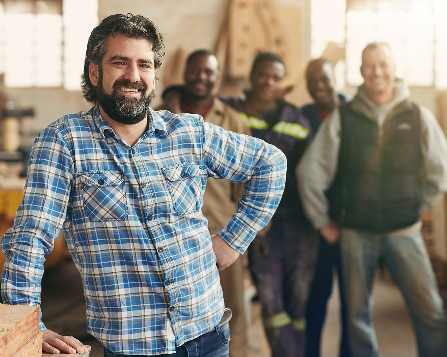 businessman standing in front of empployees in workshop